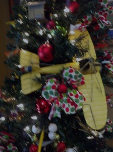 This cute yellow airplane is perched safely in the tree.  